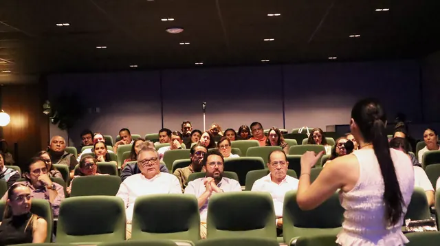 El auditorio visto desde el frente: la ponente de espaldas y la sala completa siguiendo la sesión.